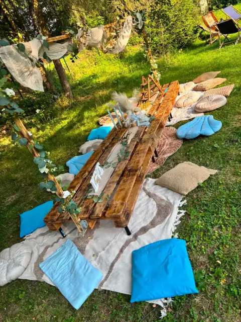 Boho piknik s dlouhým nízkým stolem a modrými polštáři
